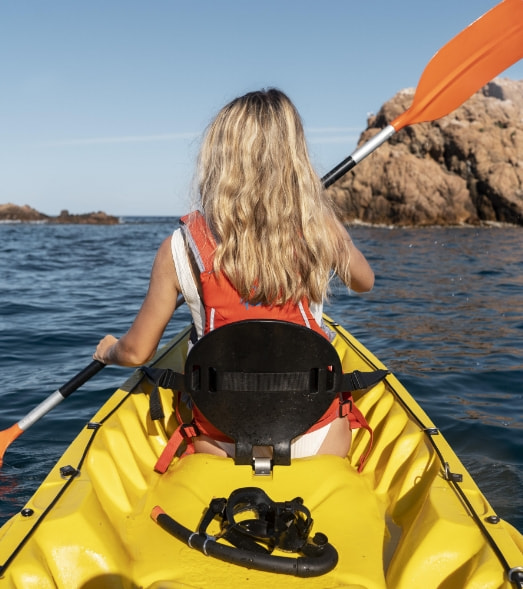 Girl kayaking in the waters of cala san vicente