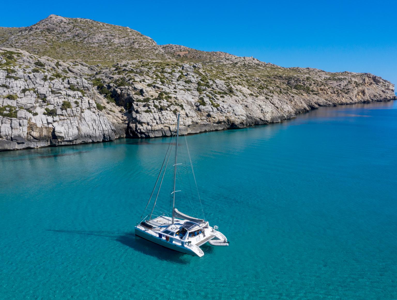 Catamaran in the crystal clear waters of the Mediterranean Sea at Cala San Vicente, Majorca.