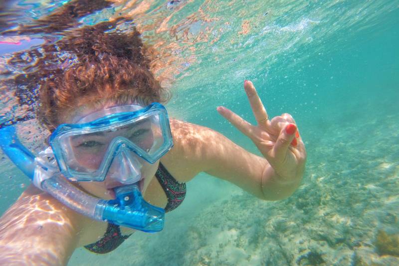 Mujer practicando snorkel en aguas transparentes