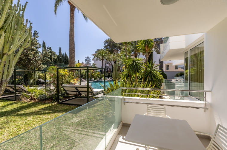 Terrace with views of the garden and pool at Apartments Hoposa Illa d'Or