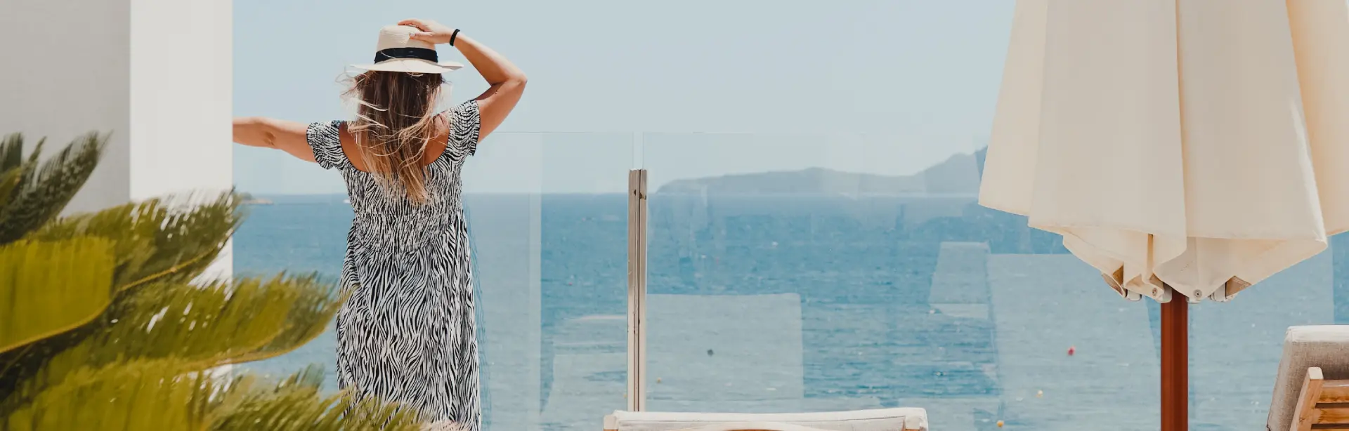 Huésped disfrutando de las vistas al mar Mediterráneo desde la terraza de un hotel Hoposa en Mallorca.